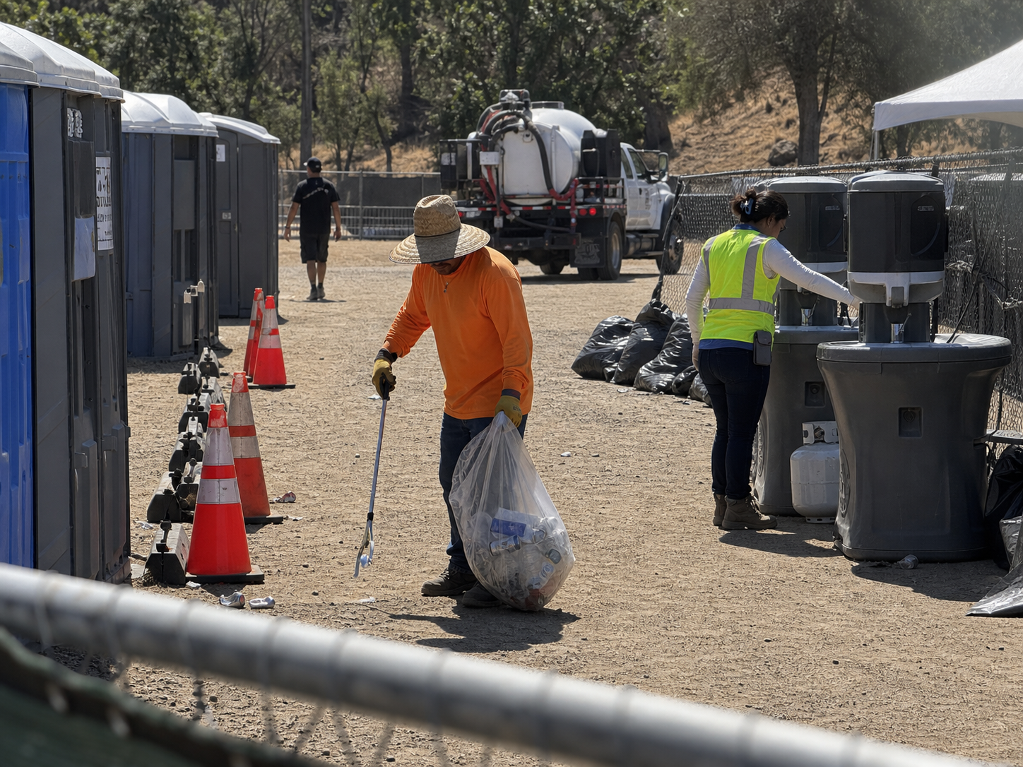Crew checking the area around portable restrooms at a park event